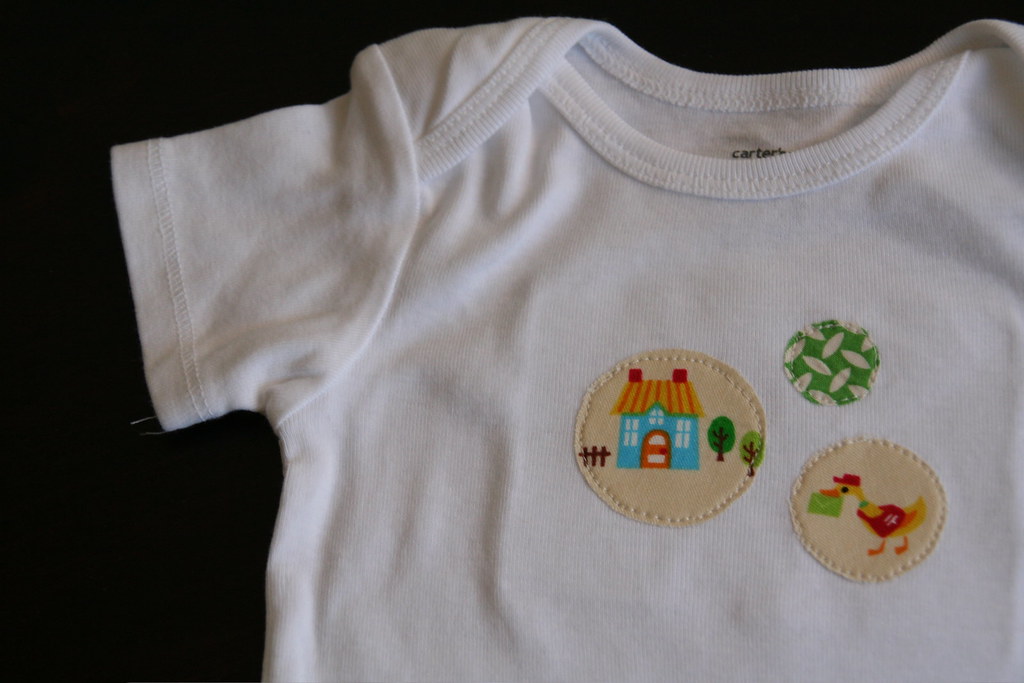 white baby onesie with three circular prints