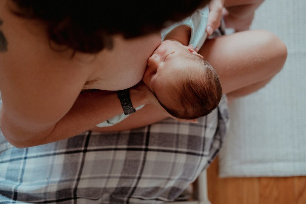 a woman breastfeeding a baby in her lap