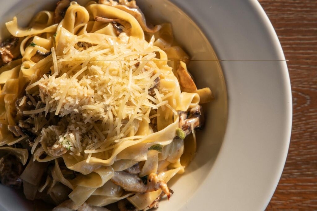 Indulge in a close-up of creamy chicken pasta topped with Parmesan, capturing the essence of Italian cuisine.