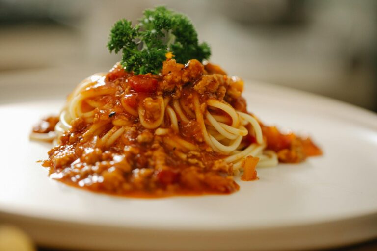 Close-up of a tempting spaghetti Bolognese dish topped with fresh parsley, perfect for Italian cuisine lovers.